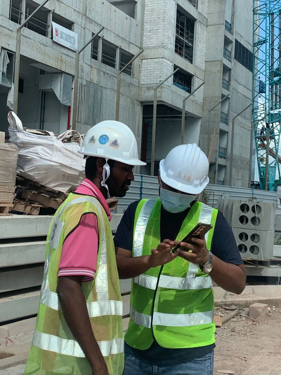 Site workers checking a permit on a mobile phone