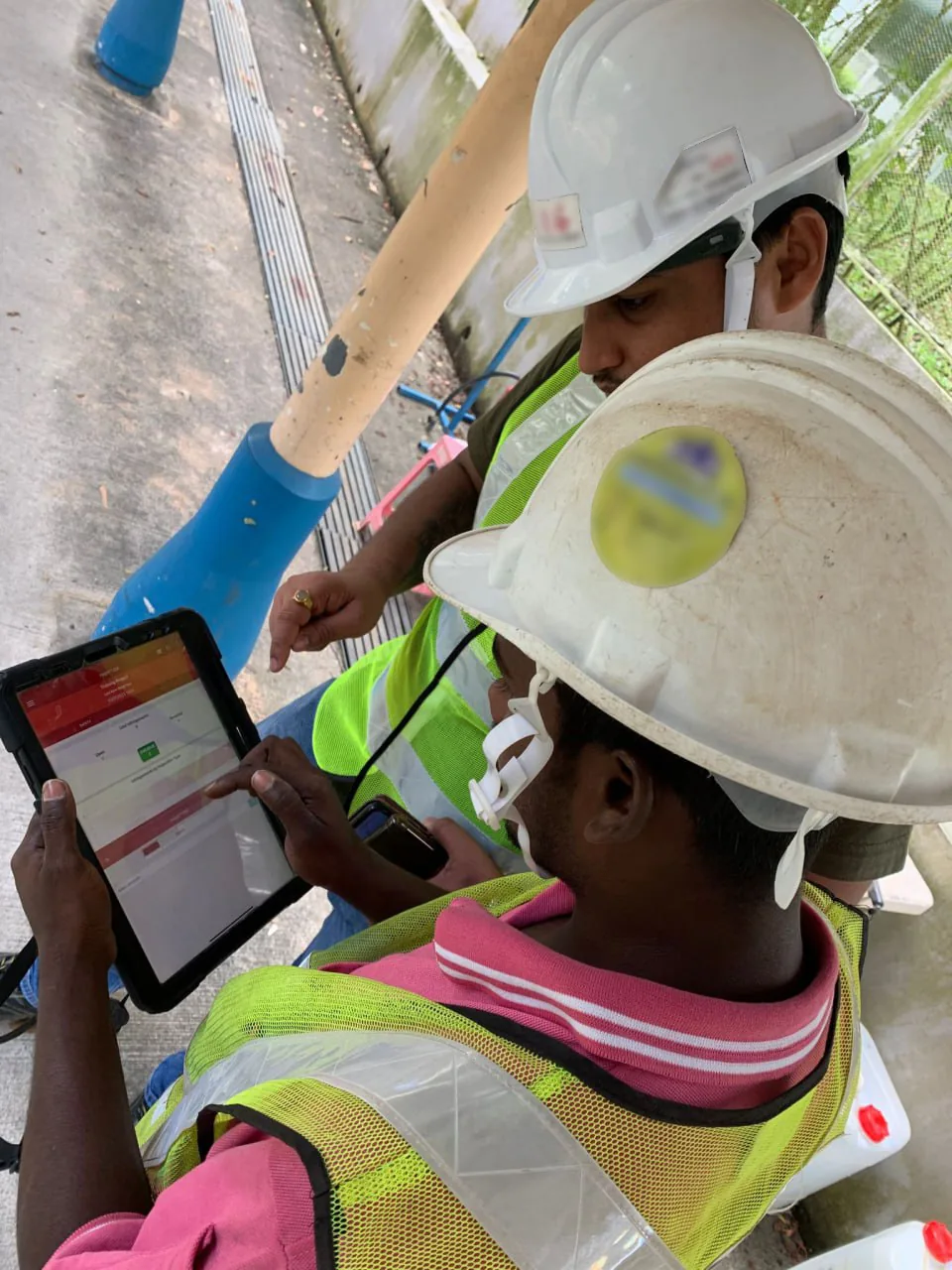Site workers reviewing an ePTW on a tablet