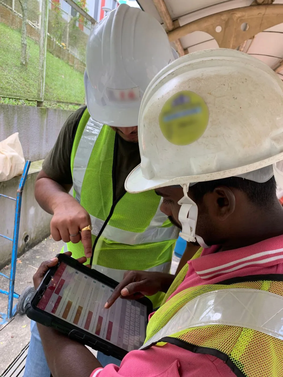 Site workers reviewing an ePTW report on a tablet